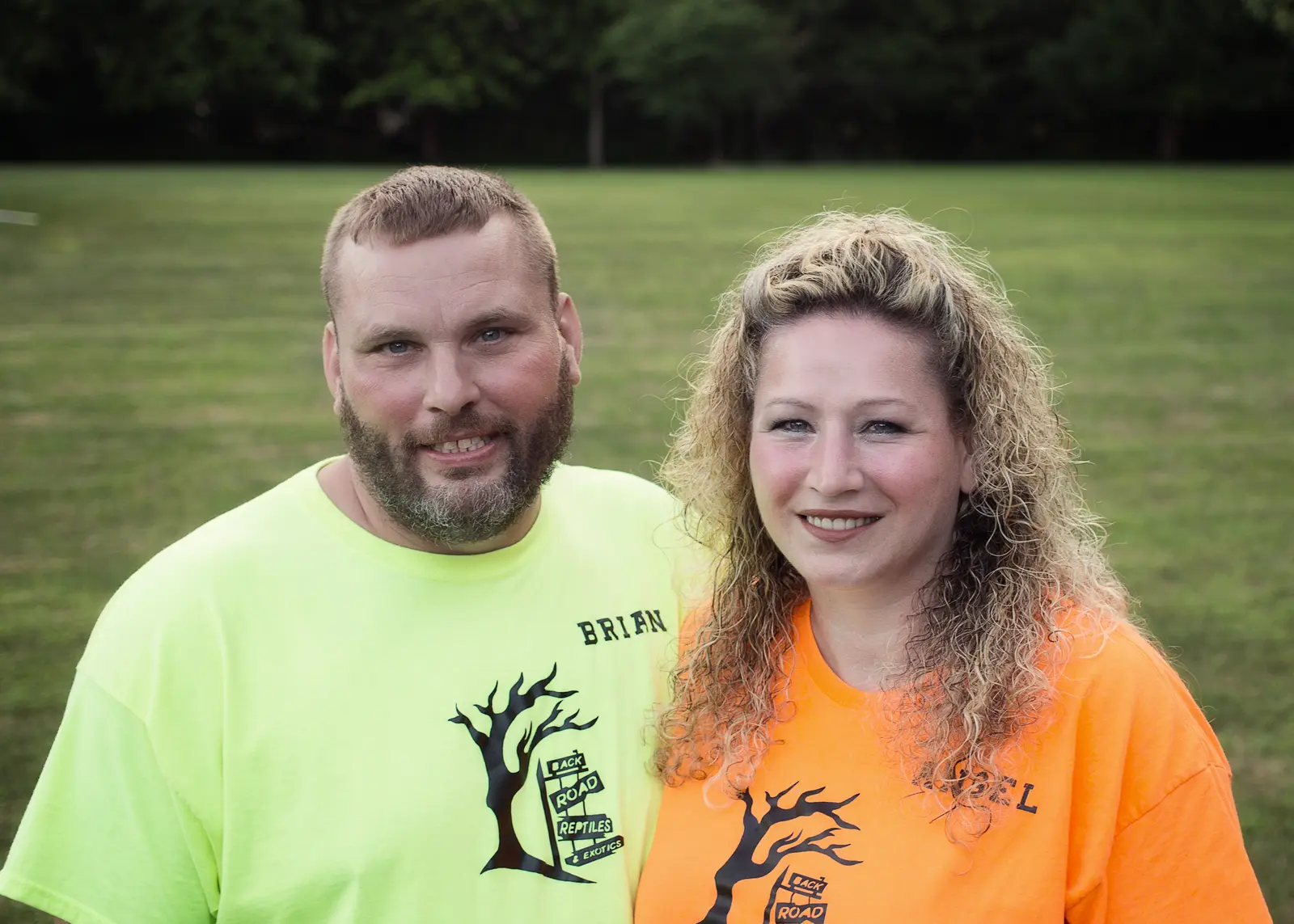 Brian and Angel, owners of Back Road Reptiles and Exotics LLC, outdoors in branded shirts